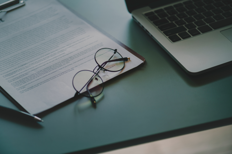 Picture of document on clipboard with glasses and laptop Picture of document on clipboard with glasses and laptop